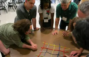 Participants work together to make a yarn net.